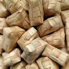 Woven palm leaf parcels filled with rice stacked together.