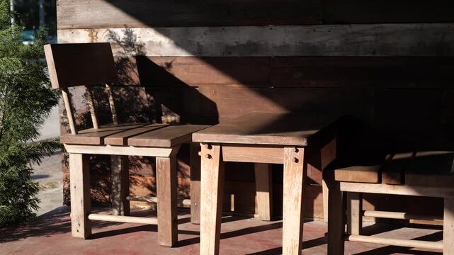 Wooden Chairs and Table with Sunlight and Shadow Creating Warm Minimal Atmosphere