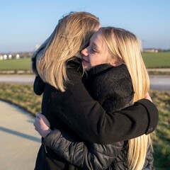 jeune fille tenant sa m&egrave;re dans ses bras, adolescente blonde et sa maman en ext&eacute;rieur