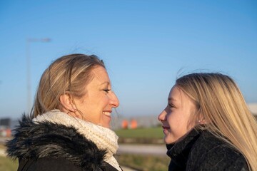 Fototapeta premium Mère et fille se regardant dans les yeux, relation familiales, femme et fille blonde