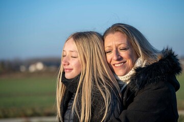 Obraz premium Portrait d'une mère et de sa fille, calin familial en extérieur
