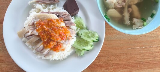 Chicken rice in a white plate on a wooden table