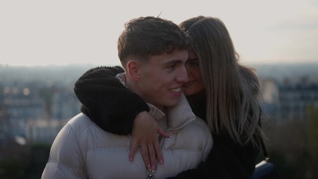 A romantic couple embraces with the Paris skyline in the background The woman hugs the man displaying affection and love Handheld shot with warm lighting capturing a moment of travel romance and conne