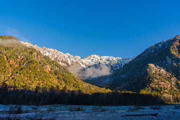 Beautiful mountains of Kamikochi National Park glowing in the morning sunlight during autumn in Nagano, Japan.