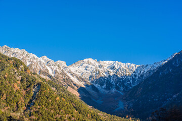 Beautiful mountains of Kamikochi National Park glowing in the morning sunlight during autumn in Nagano, Japan.