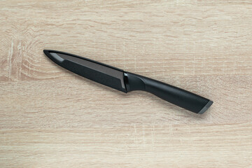 Ceramic Kitchen Knife on Wooden Surface: Modern Culinary Tool for Efficient Cooking