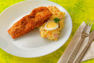 Traditional Czech Christmas fried carp with potato salad on plate