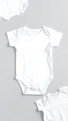 Three white baby bodysuits on a gray background