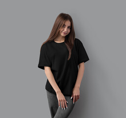 Mockup of a black oversized t-shirt on a girl, front view, for design, pattern, print, branding, advertising.