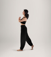 Mockup of black wide pants for yoga, top on a woman in asana, side view in full height, for design, pattern, branding.