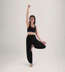 Mockup of black wide pants for yoga, top on trainer in asana, front view in full height, isolated on background.