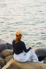 young woman sitting on the rocks