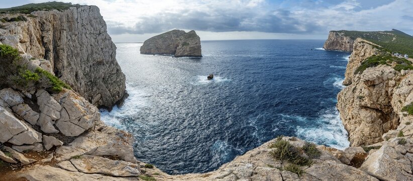 Steep cliffs by the sea and the rocky island of Isola Foradada, Belvedere Foradada, cliffs on the Capo Caccia headland, Alghero, Sardinia, Italy