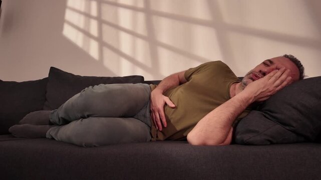 Man with gastritis, chest, stomach and abdominal pain at home.