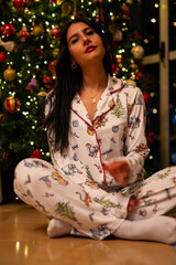 girl in pajamas near the christmas tree