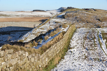Image of Hadrian's Wall taken in an easterly direction showing walkers contending with the steep and icy footpath in the Steel Rigg area near Sycamore gap