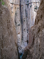Image of the precipitous drop on the dangerous Caminito (Camino) del Rey footpath, near Ardales, Spain, set against the vertical bedding planes of the stone within the canyon