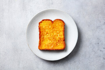 French toast on a white plate. Grey background. Top view.