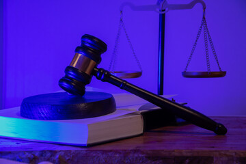 A judge's gavel with the scales of justice next to a book of laws. The integrity of the judicial system. Legal decisions and justice in court. Law firm