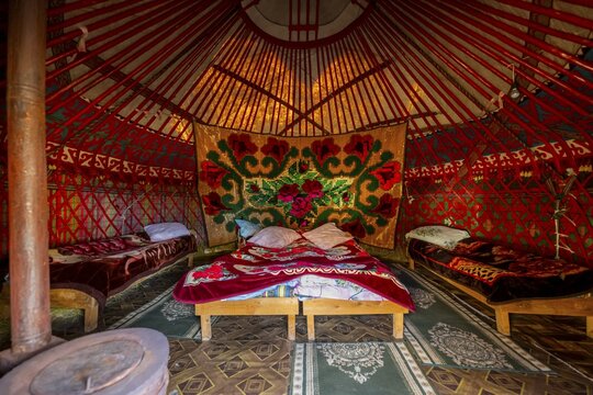 Traditional Kyrgyz yurt for overnight accommodation for tourists, with four beds and carpets, Naryn region, Kyrgyzstan