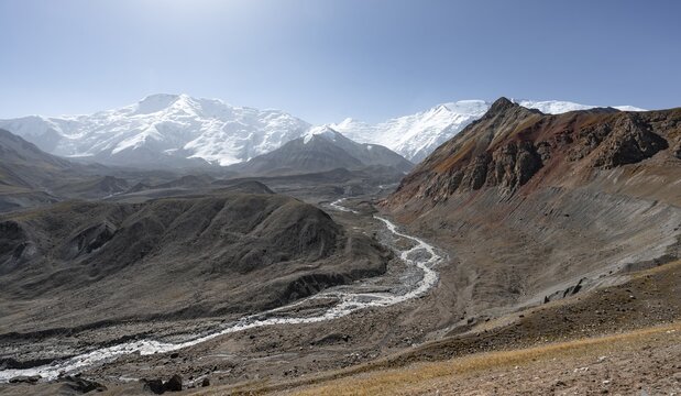 Valley with river Achik Tash, behind glaciated and snow-covered mountain peak Pik Lenin and Pik of the XIX Party Congress of the CPSU, Trans Alay Mountains, Pamir Mountains, Osh Province, Kyrgyzstan