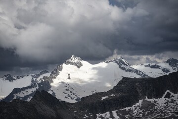 Glaciated rocky mountain peaks, Hornspitze summit, dramatic cloudy sky, Zillertal Alps, Tyrol, Austria