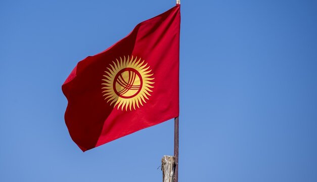 Kyrgyz national flag in front of a blue sky, Kyrgyzstan