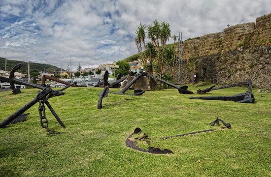 Old anchors lie on a green meadow in an open-air museum of maritime history, Horta, Faial Island, Azores, Portugal