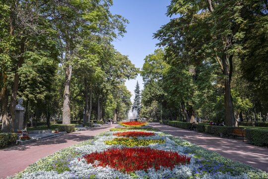 Strollers, flower bed in Panfilov Park, municipal park in Bishkek, Kyrgyzstan