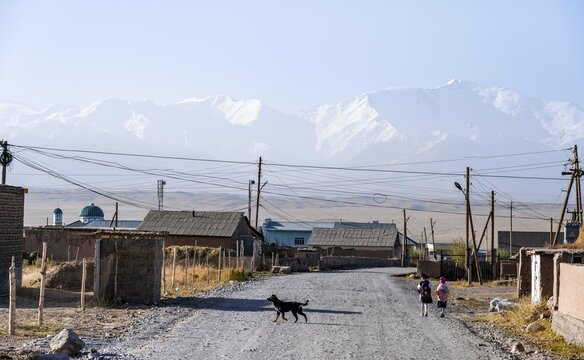 Schoolchildren and dog in the village of Sary Mogul, snow-capped mountains, Pamir Mountains, high mountains, Transalai Range, Alay District, Kyrgyzstan