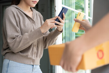 Happy Asian woman scan QR code for pay goods delivery. Delivery man send deliver express. online shop, paper container, takeaway, postman, delivery service, packages, electronic money