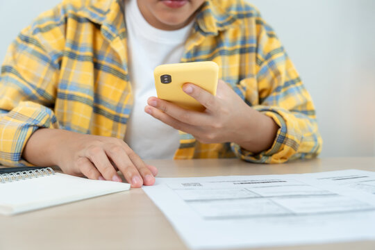 Modern female use phone to scan barcode or QR codes to pay credit card bill after receive document invoice. payment, receive, paying electricity, digital payments without money, technology, scanning - Powered by Adobe