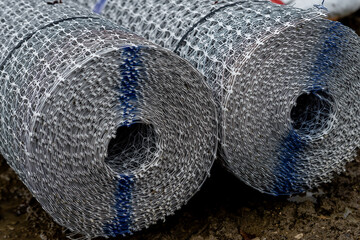 Close-up of the roll of white plastic geogrid mesh with intricate pattern and texture