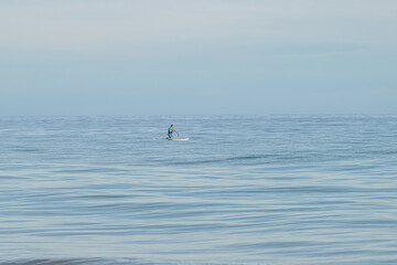 Naklejka premium Man with SUP Stand Up Padle Paddle Sky view in Corsica bay on the Ocean