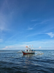 small local boats on turquoise tropical wave sea near philippines islands with beautiful sand beach on sunny day