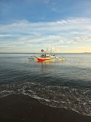 small local boats on turquoise tropical wave sea near philippines islands with beautiful sand beach on morning dawn