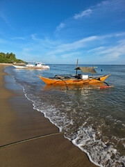 small local boats on turquoise tropical wave sea near philippines islands with beautiful sand beach on morning dawn