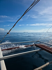 small local boats on turquoise tropical wave sea near philippines islands with beautiful sand beach on sunny day