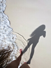 shade on young woman on beautiful white sand beach on sunny day near turquoise tropical wave sea. philippines islands. vertical