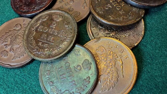 A collection of vintage Russian Empire 2 kopeck coins on a green surface.