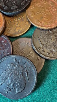Close-up of vintage Russian Empire 2 kopeck coins on a green surface.