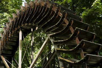 Wooden wheel with paddles delivers water to the saline Gradierwerk, also known as a saline graduation tower. Bad Kreuznach, Rhineland Palatinate, Germany.