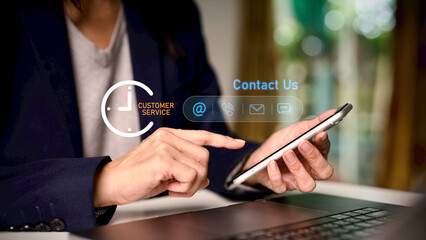 Business professional using smartphone and laptop with customer service icons for contact us, support, communication and response time, representing omnichannel support and digital service experience