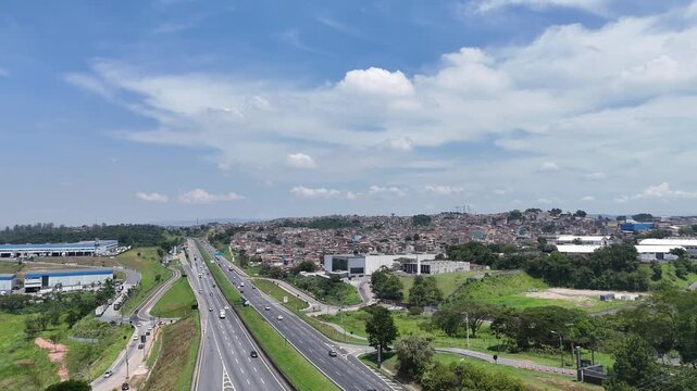 Vis&atilde;o v&iacute;deo 4k a&eacute;rea mostra favela pr&oacute;xima &agrave; rodovia, destacando a desigualdade urbana.