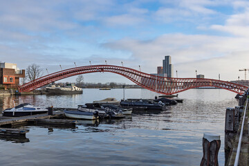 The iconic red Python Bridge (Pythonbrug) spanning the canal in Amsterdam's Eastern Docklands, connecting Sporenburg and Borneo Island.