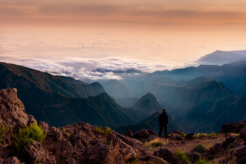 Madeira, Portugal, sunset near Pico do Arieiro. Sunset colors, a man admiring the beauty and lush mountains of Madeira.