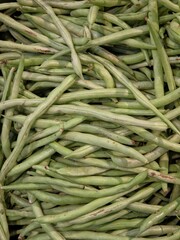 Overflowing pile of fresh green beans (also known as string beans or snap beans). vertical view.