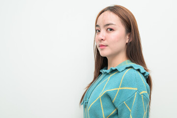 Profile view portrait of a young Asian woman against white background