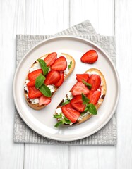 Two grilled cheese toast topped with strawberries and mint