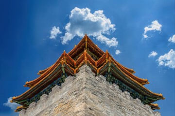 A stunning close-up view of the corner turret of the Forbidden City in Beijing, showcasing its intricate architectural design and colorful roof against a bright blue sky with scattered clouds. © VisualCoordinates